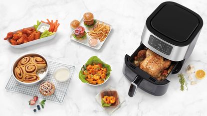 Cuisinart basket air fryer (AIR-200) with prepared food with on white marble countertop