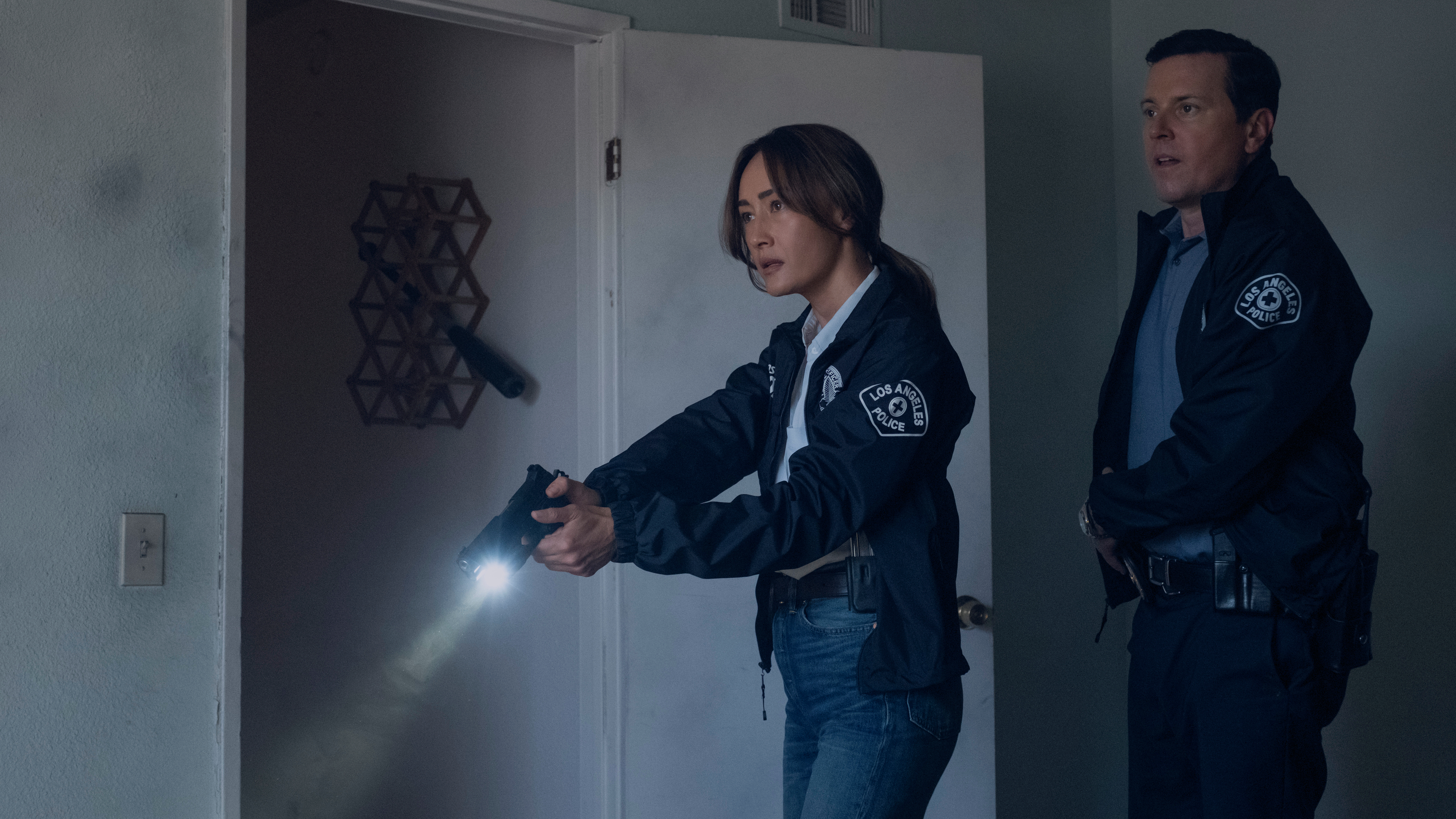 L-R: Renée Ballard (Maggie Q) and Ted Rawls (Michael Mosley) armed with pistols in a scene from Prime Video's "Bosch" spinoff, "Ballard"
