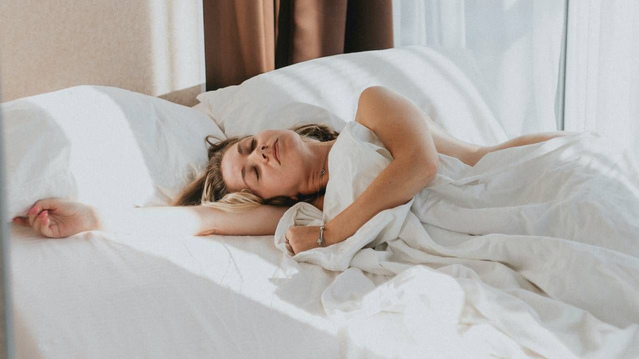 Woman curled up in a duvet sleeping