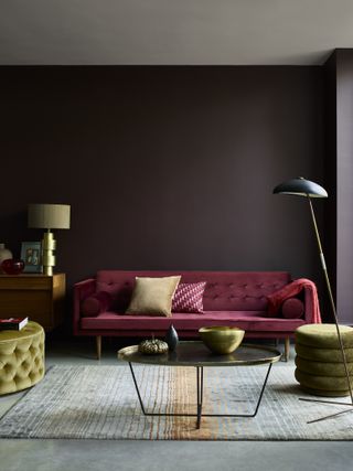 Ideas for living room paint colors shown in a dark chocolate brown, with a plum colored velvet sofa, green velvet pouffes and metal accents.