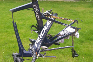 A very smashed up Ridley bike on grass