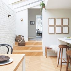 Kitchen-diner area with wooden floor, white walls, and a kitchen breakfast bar area