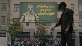 (L to R) a crowd of people under a billboard with a superhero that reads "Helping you get your minds right!" look up at Jharrel Jerome (as Cootie)