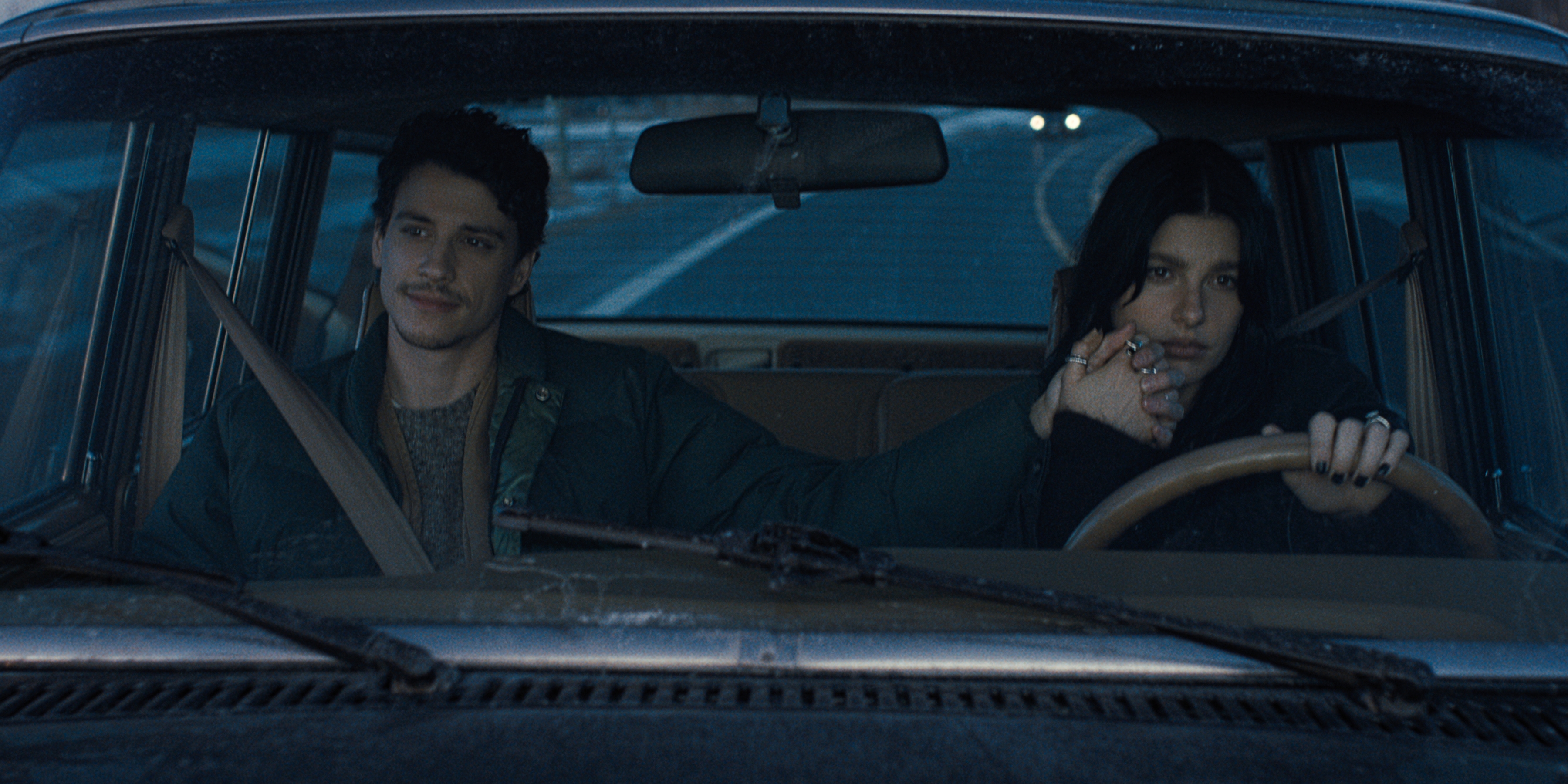 Адам ДиМарко в роли Ники Каннингема и Камила Морроне в роли Рэйчел Харкин вместе едут в машине, держась за руки, в кадре из фильма «Что-то очень плохое произойдет»
