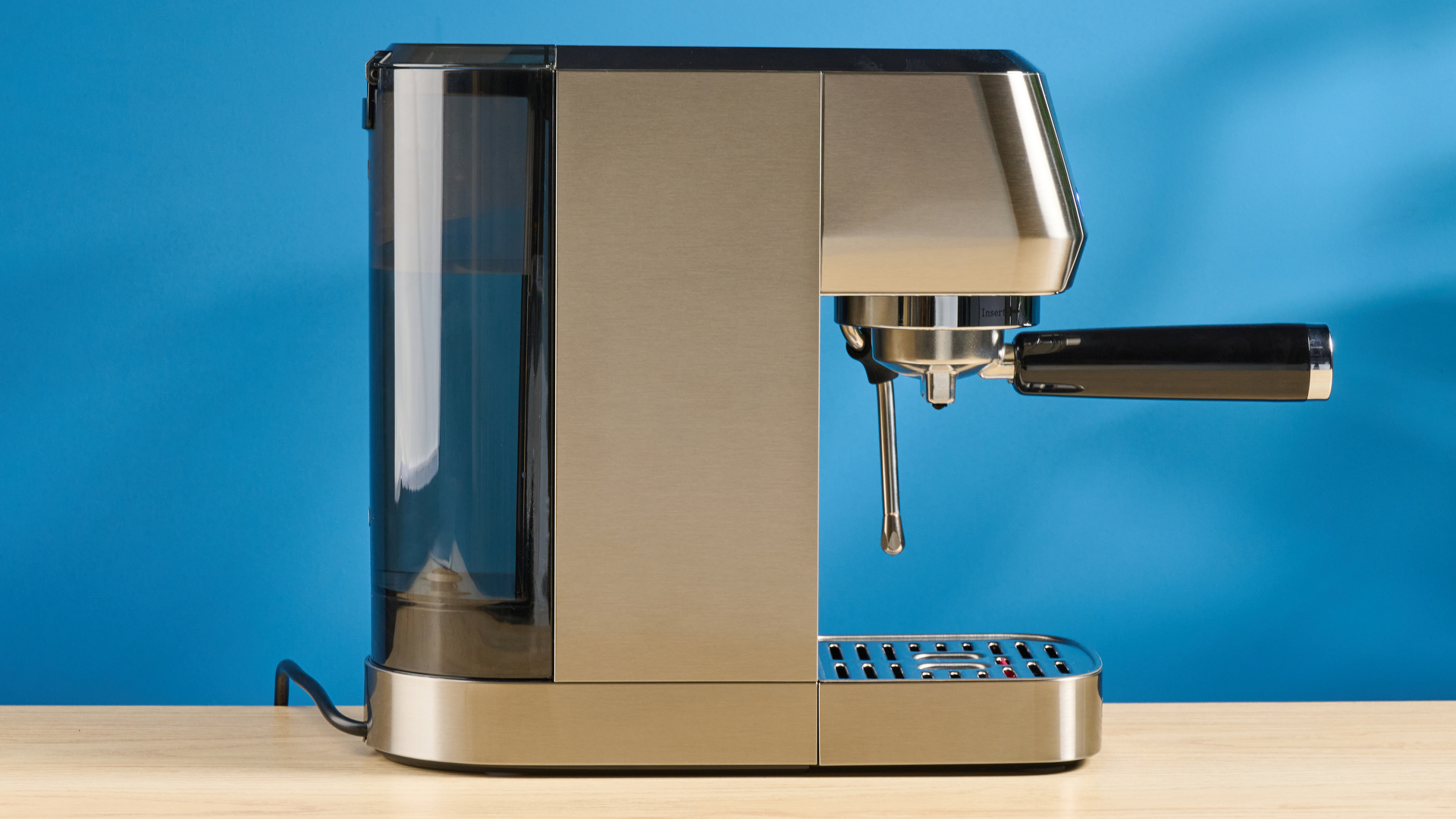 the casabrews 3700 essential espresso machine photographed against a blue background in stainless steel
