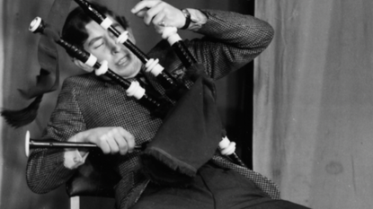 Prince Charles, the Prince of Wales, joking around with a set of bagpipes as he appears on stage in a student revue in 'Quiet Flows the Don', at Trinity College, Cambridge University, February 23rd 1970
