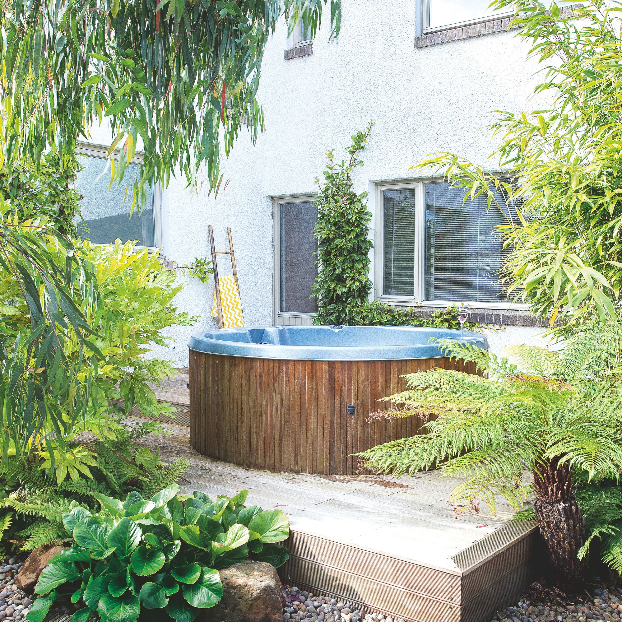 A wooden tub on a raised decking in front of a house