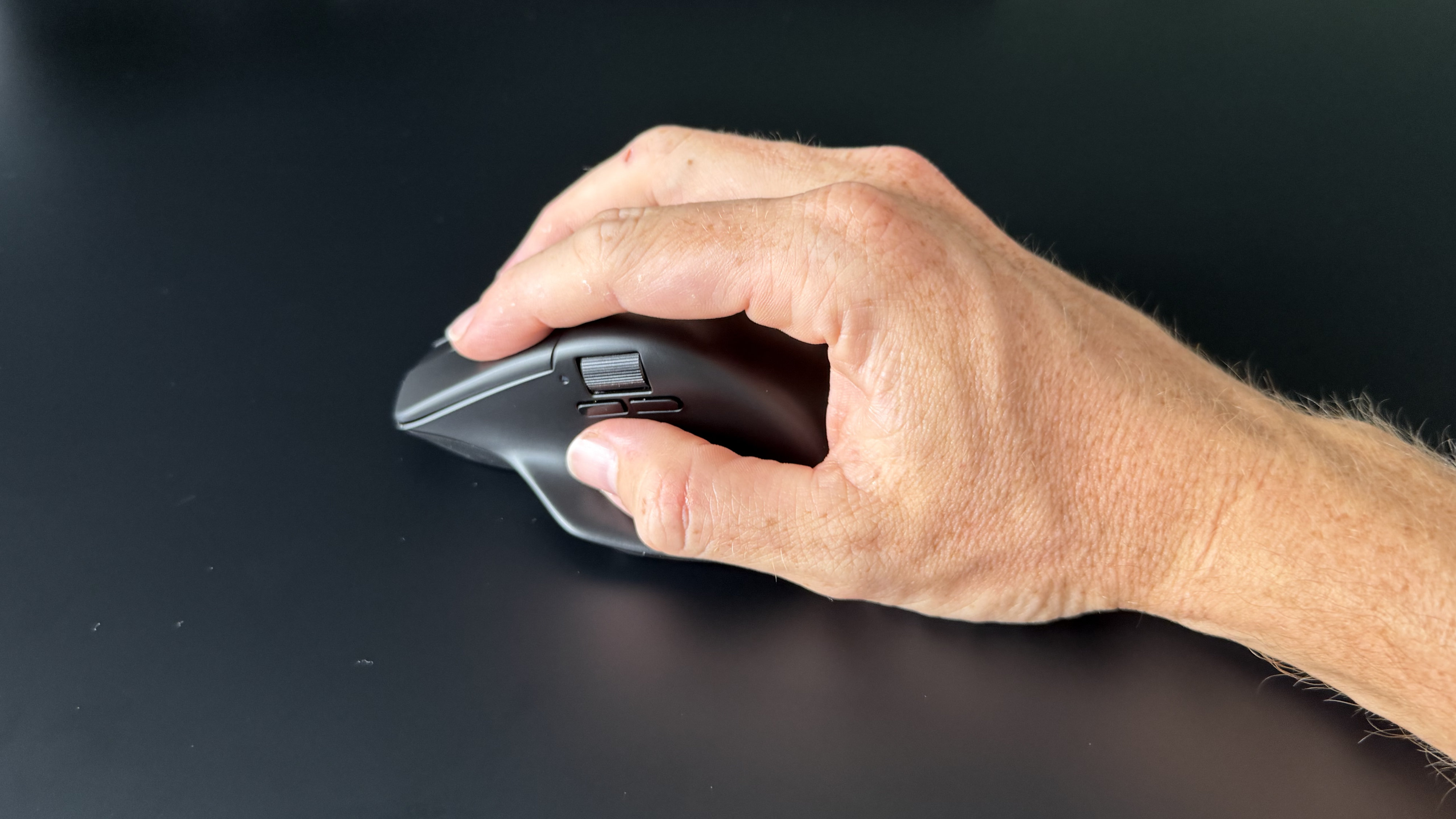 A man's hand holding the Keychron M6 8K