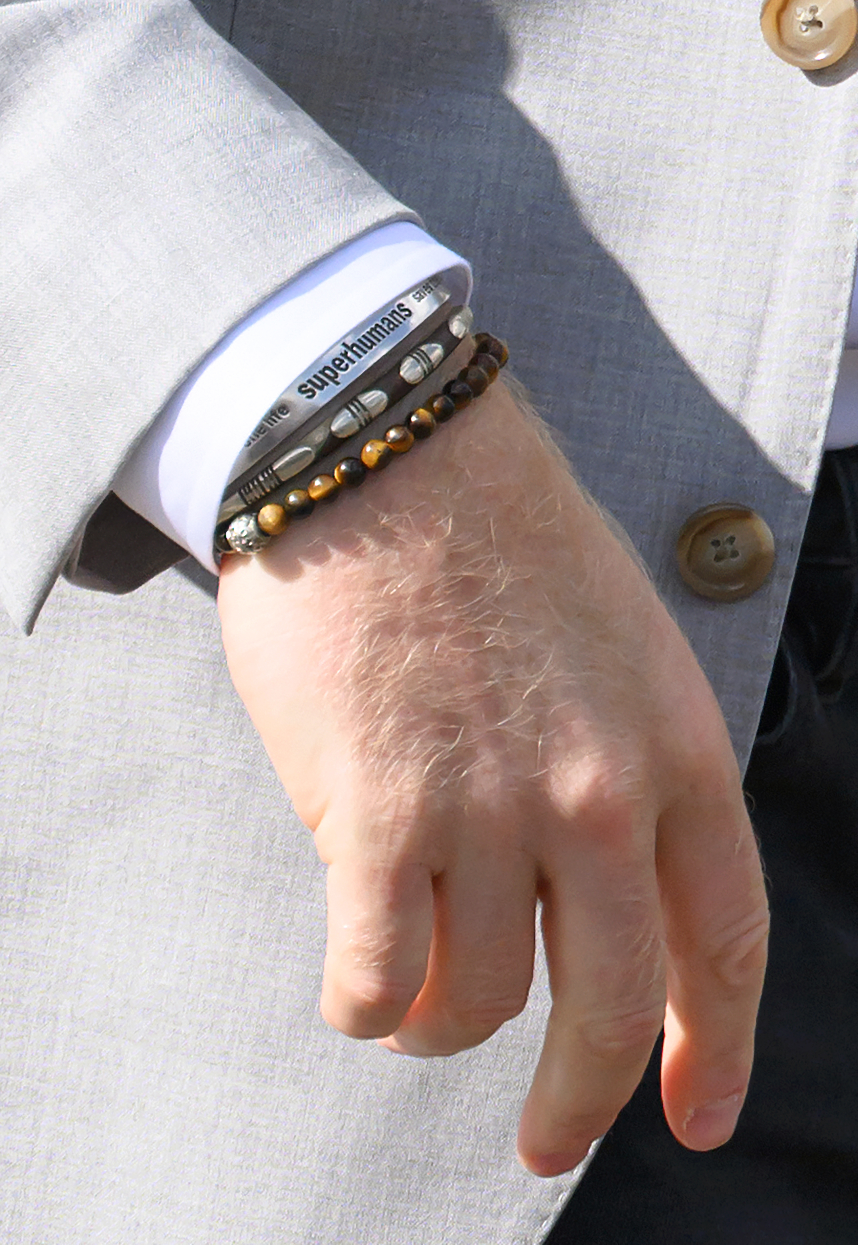 A closeup of Prince Harry's wrist with three bracelets
