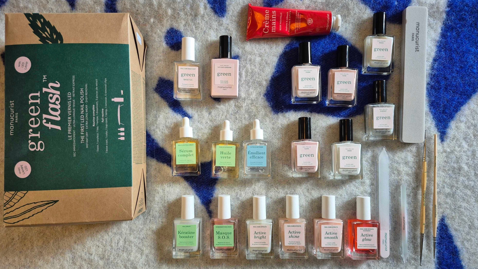 A collection of Manucurist nail polish, tools and treatments owned by Digital Beauty Writer, Naomi Jamieson - all laid out on a blue and white blanket background.