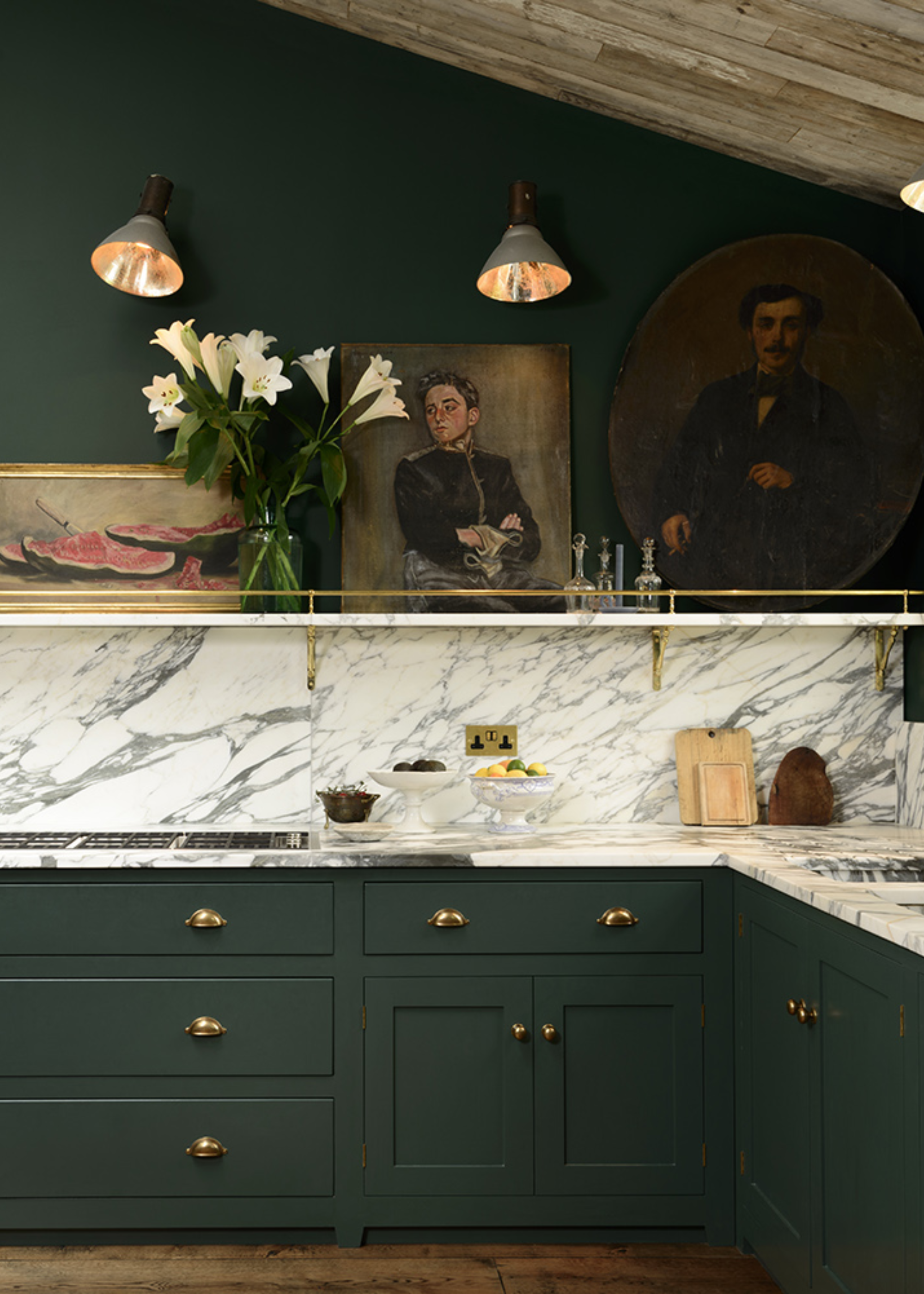 An emerald green kitchen with a marble backsplash and counter