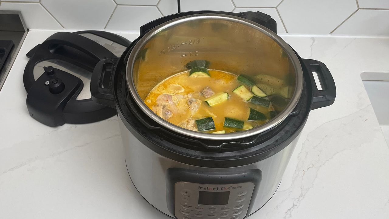 Instant Pot Duo Crisp &amp; Air Fryer on a kitchen countertop being used to cook curry