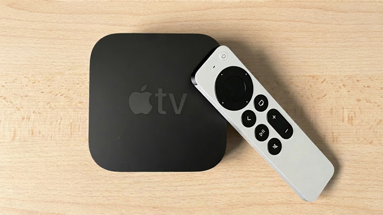 Apple TV 4K sitting on wooden desktop (shown from above)