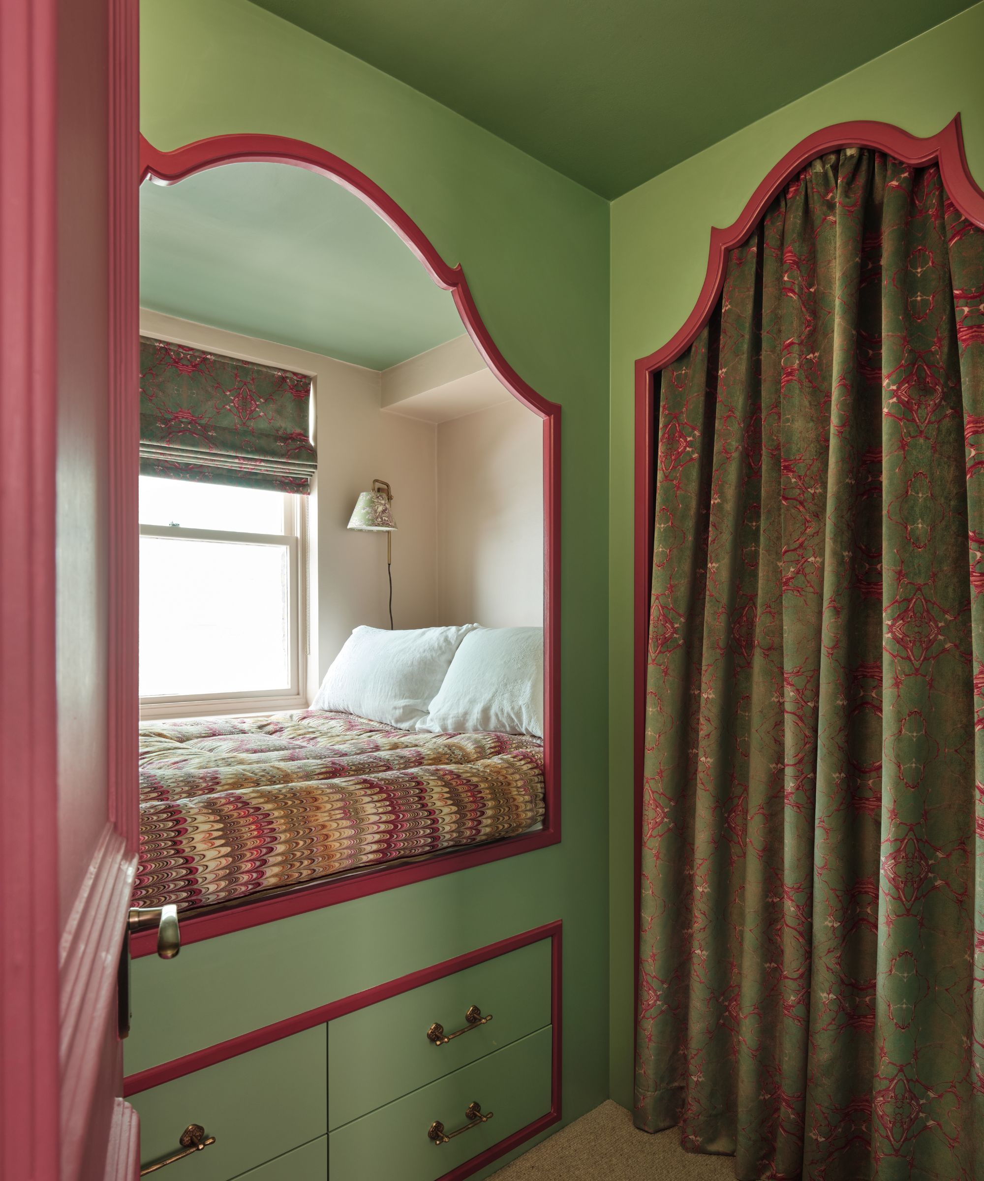 Green and pink bed nook with floral blind and curtain, chevron quilt and built-in drawers