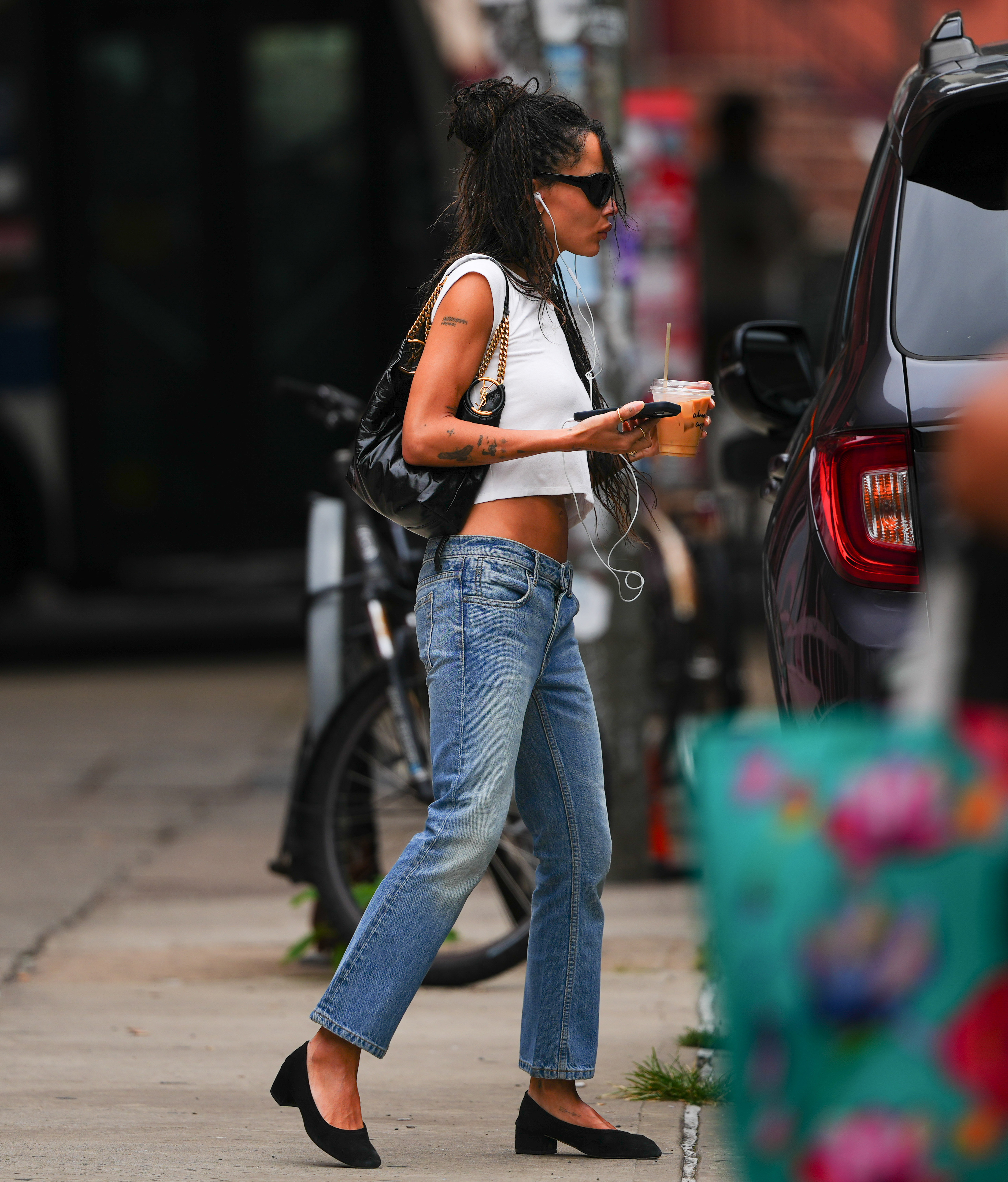 Zoe Kravitz wears the ballet flats trend with distressed jeans and white T-shirt on August 22, 2026 in New York City