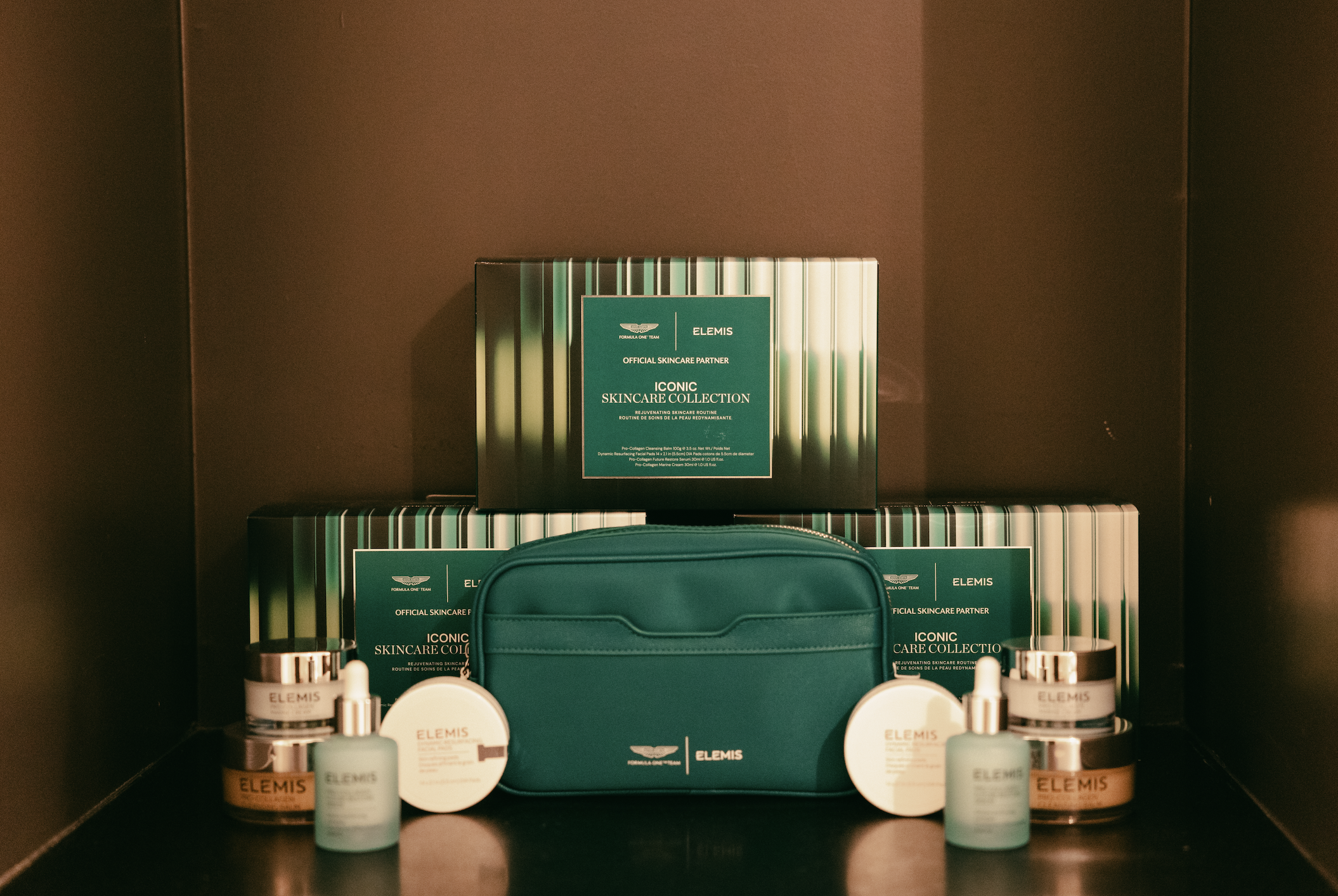 a collection of skincare products in one and green packaging on a brown backdrop