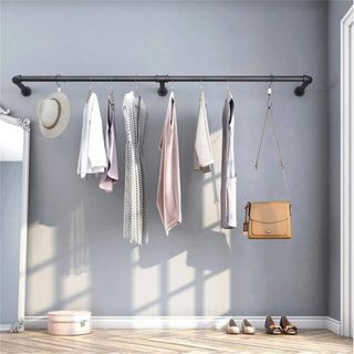 Grey wall with mounted clothes rail and hanging garments