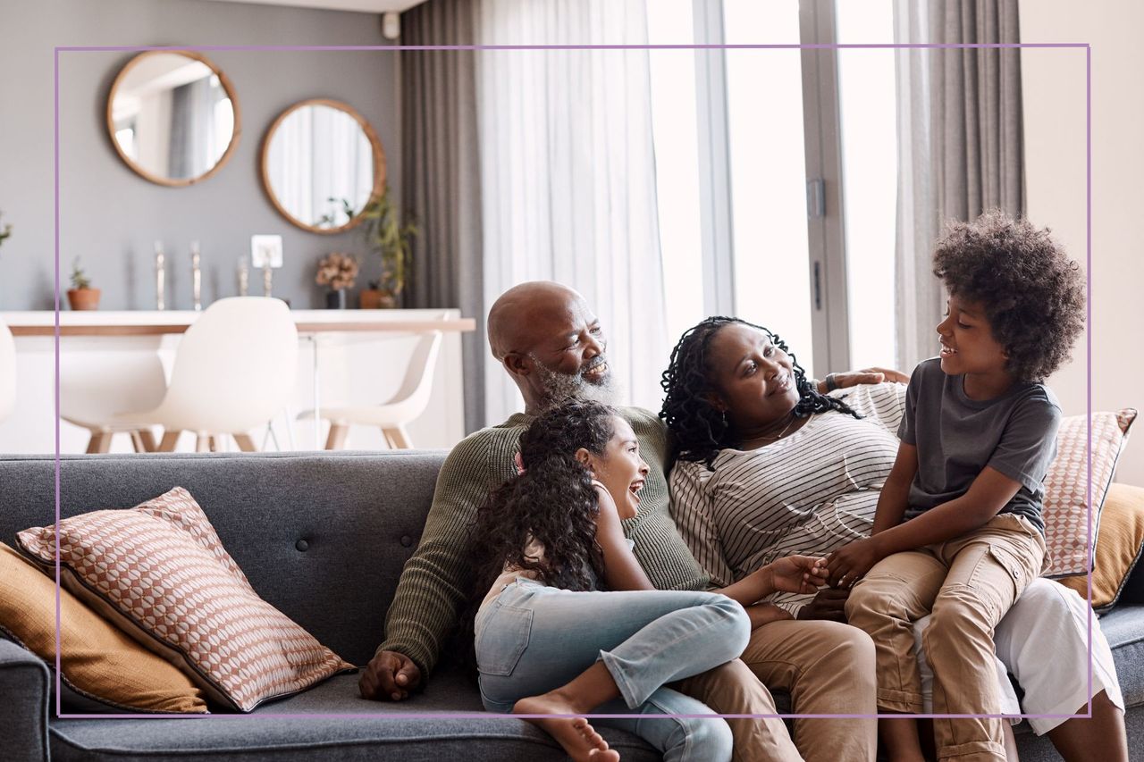 man and woman with kids on a sofa