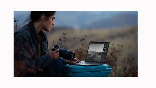 Image shows a woman in nature working on photo edits on a MacBook Pro M1.