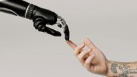 An image of a human hand touching an AI-powered robot hand
