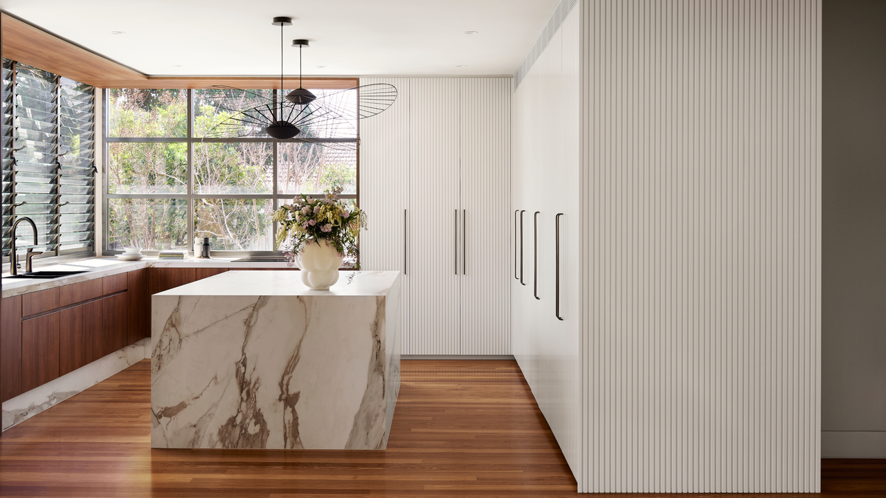 A kitchen with hardwood floors and a marble island 