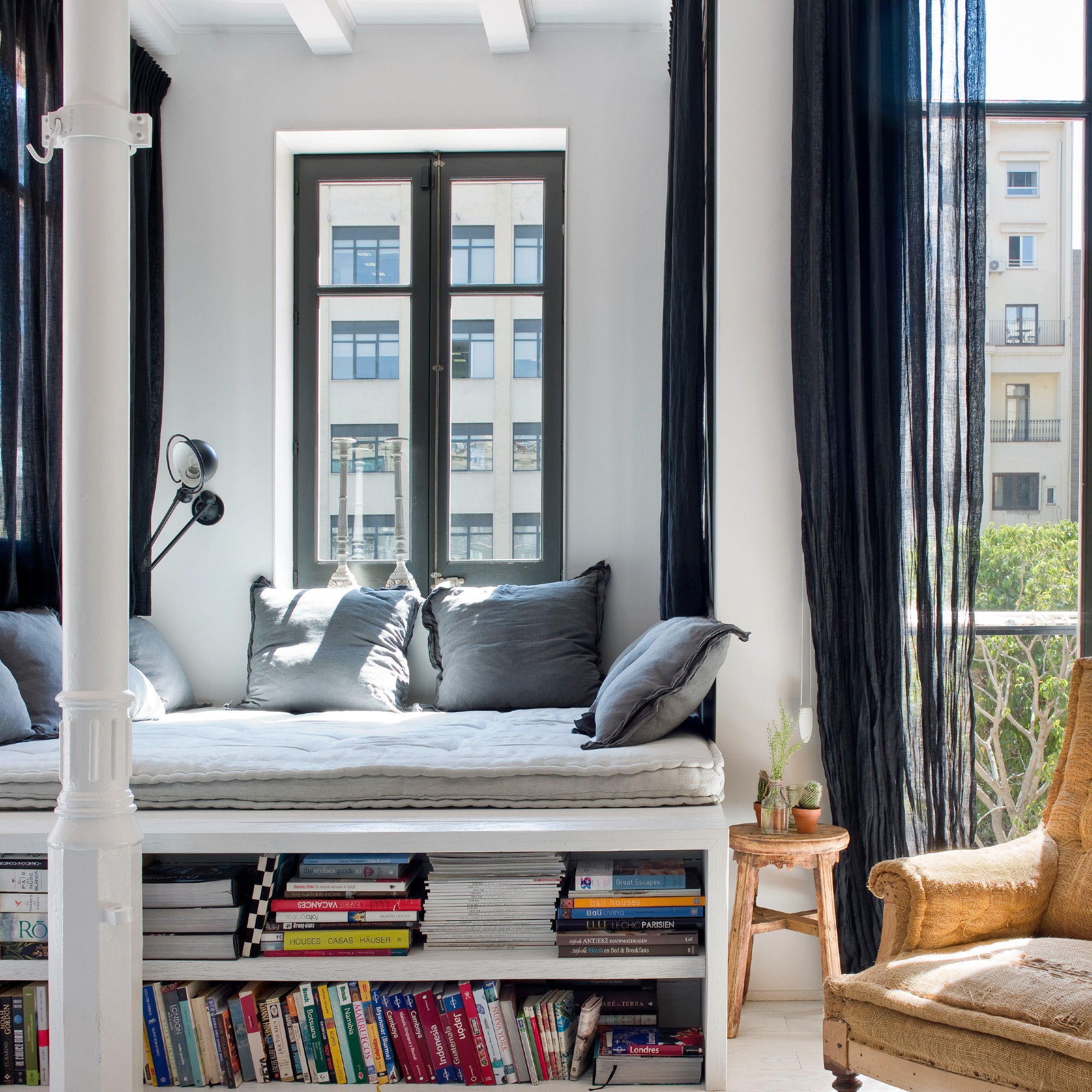 A reading nook with cushions and a low bookcase