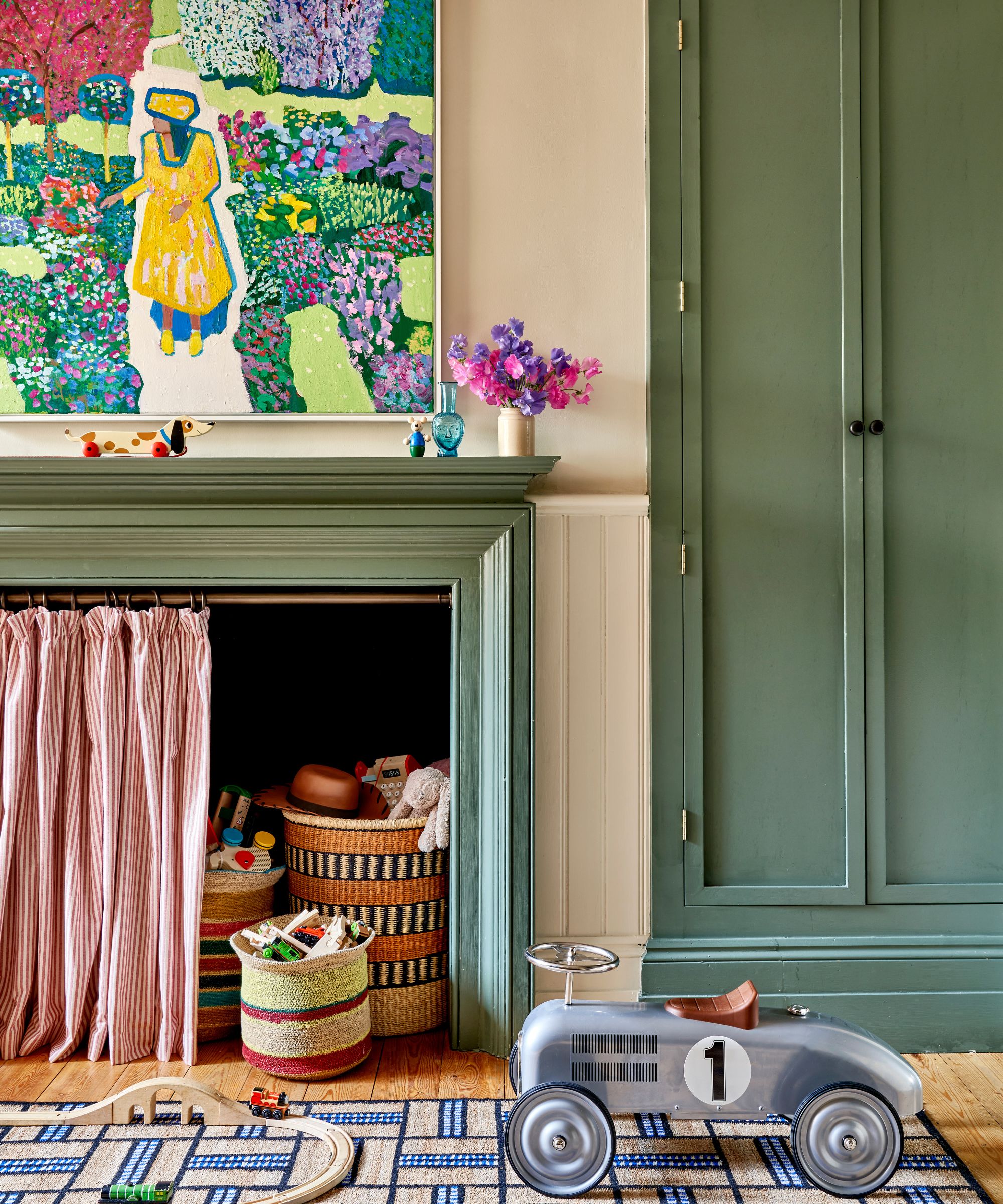 Kids bedroom with cream walls and green painted fireplace and matching built in wadrobe