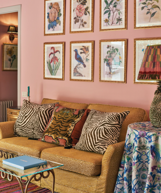 Pink room with animal print throw pillows and floral gallery wall is Belmond La Residencia