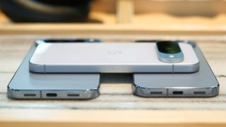 A Pixel 10 in frost stacked on a Pixel 10 Pro and Pixel. 10Pro XL in moonstone