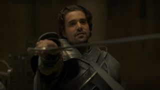Fabien Frankel as Criston Cole holding up a sword on House of the Dragon.