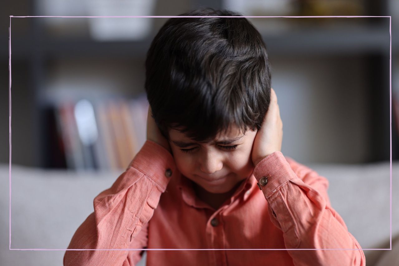 Young boy covering his ears