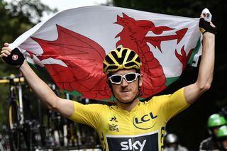 Geraint Thomas (Team Sky) carries the Welsh flag over his head during the last stage at the Tour de France