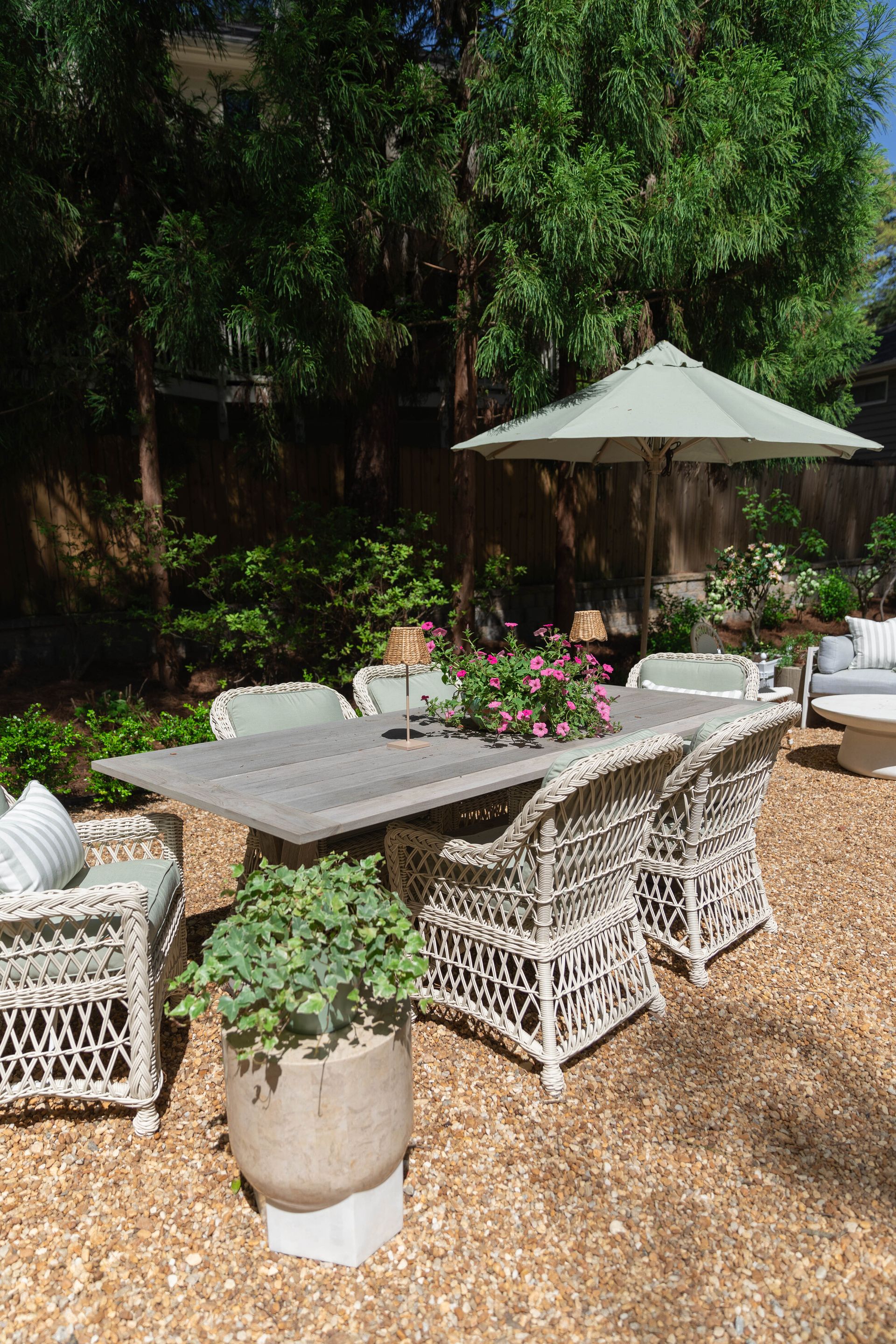 A backyard with pea shingle and wicker furniture
