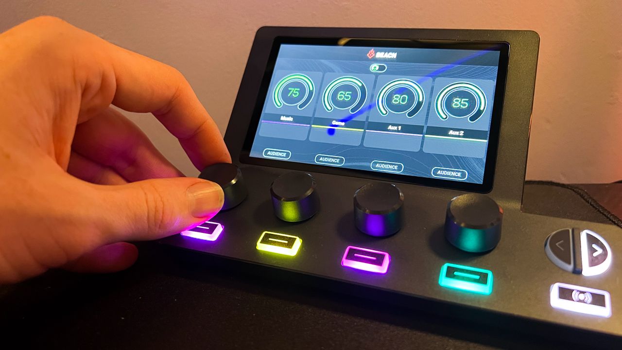 BEACN Mix Create display and tuning knobs, with the far left one being turned by the reviewer.