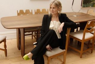 woman in black suit and green shoes