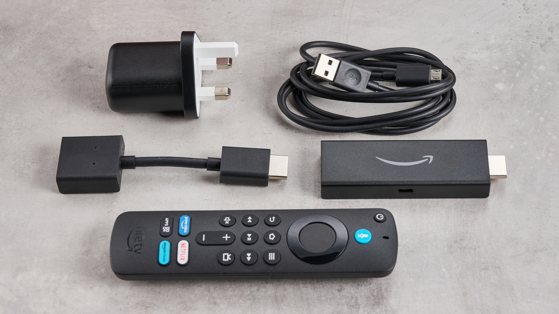 Image shows the Amazon Fire TV Stick HD with its remote control, HDMI extender, power cable, and power adapter.