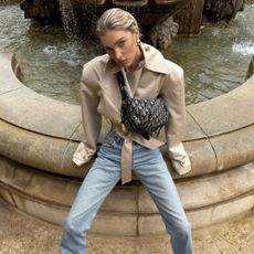 Elsa Hosk wears a cropped trench coat with jeans.