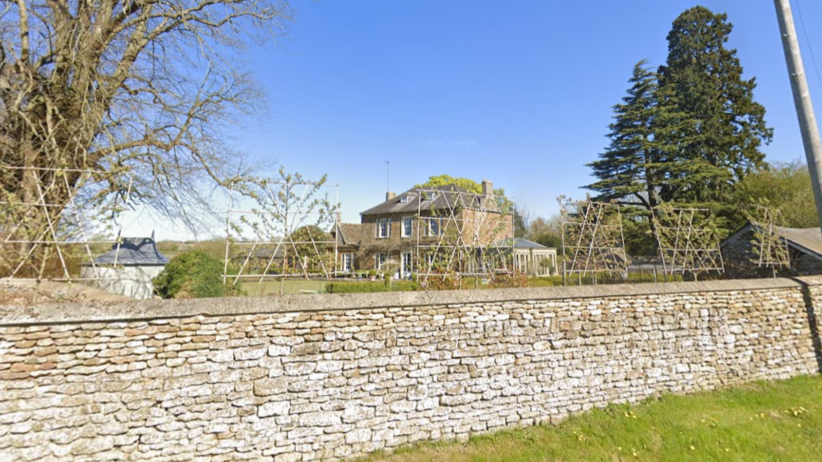 An image of a Christian Horner and Geri Halliwell&#039;s brick house with stone wall around the perimeter