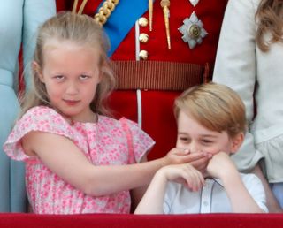 Savannah Phillips puts her hand over Prince George of Cambridge's mouth as they stand on the balcony of Buckingham Palace during Trooping The Colour 2018 on June 9, 2018 in London, England.