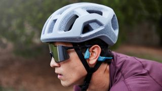 A rider on a bike wears shokz headphones