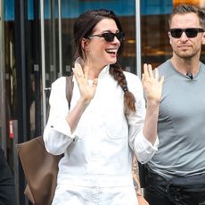 Anne Hathaway wearing a white jumpsuit and embellished flip-flops in Manhattan