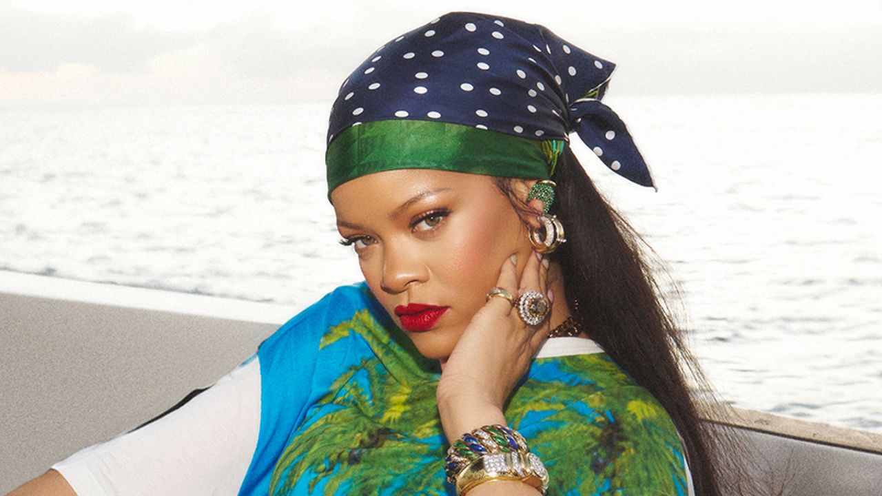 Rihanna on a boat wearing a silk scarf in her hair and a printed top