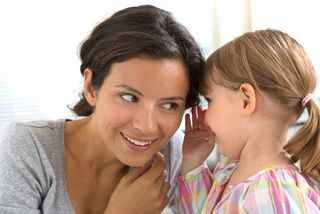 A mom listens as her daughter tells a secret.