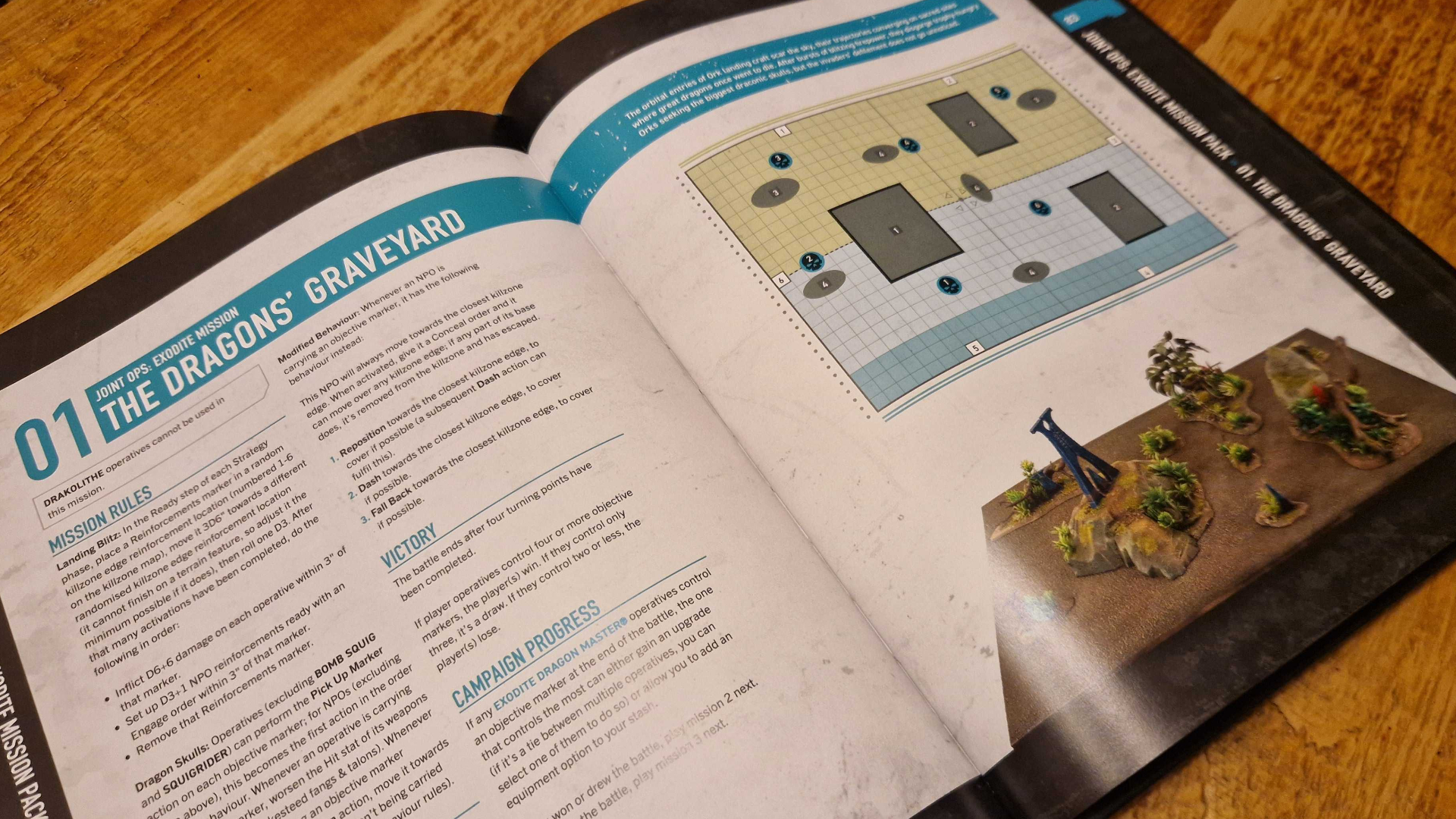 A mission from Kill Team: Exodite's rulebook laid open on a wooden table