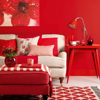 red living room with table lamp and cushions