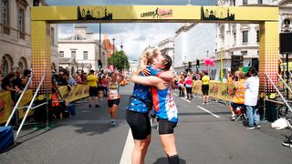 Women hug after crossing the finish line during the London Landmarks Half Marathon on August 1, 2021 in London, England.