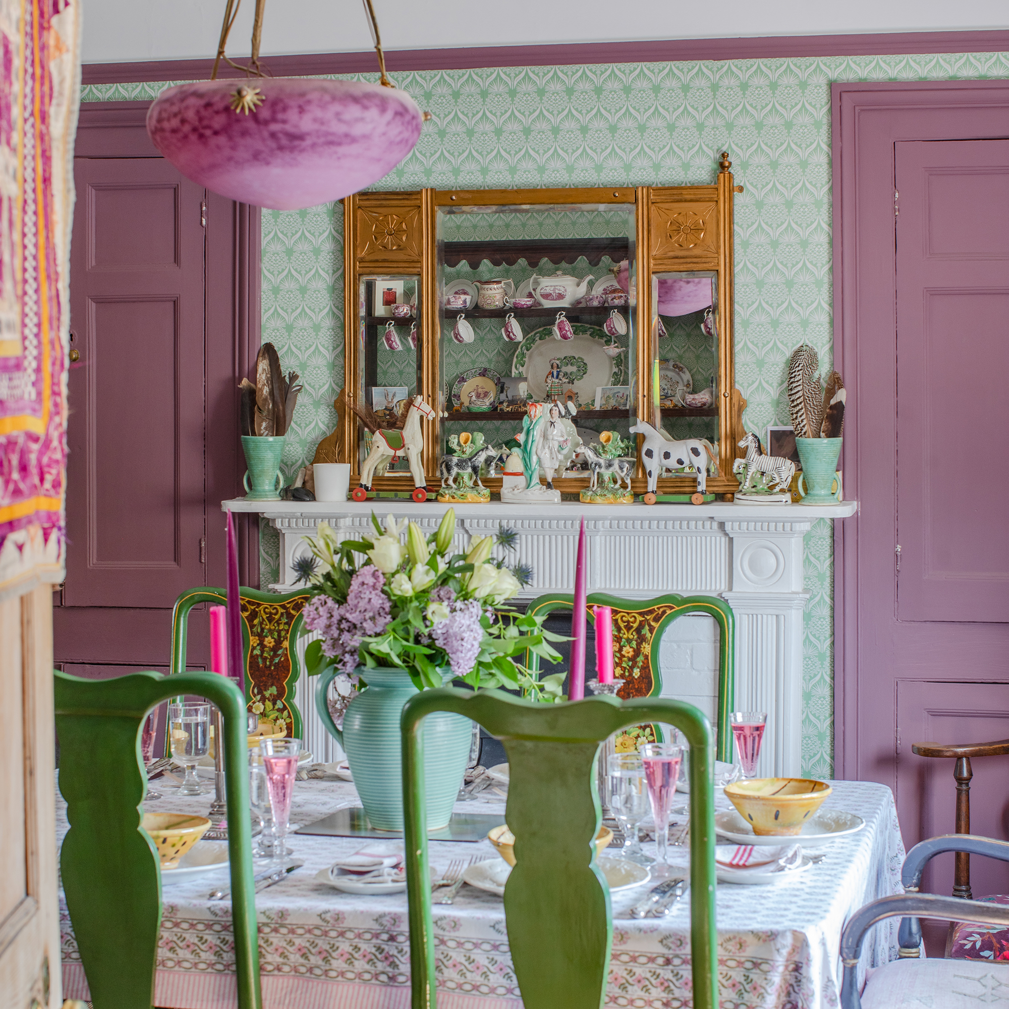 pink and green vintage style dining room with antique accessories, pink woodwork and green patterned wallpaper