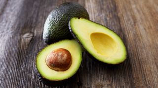 open avocado on wooden table