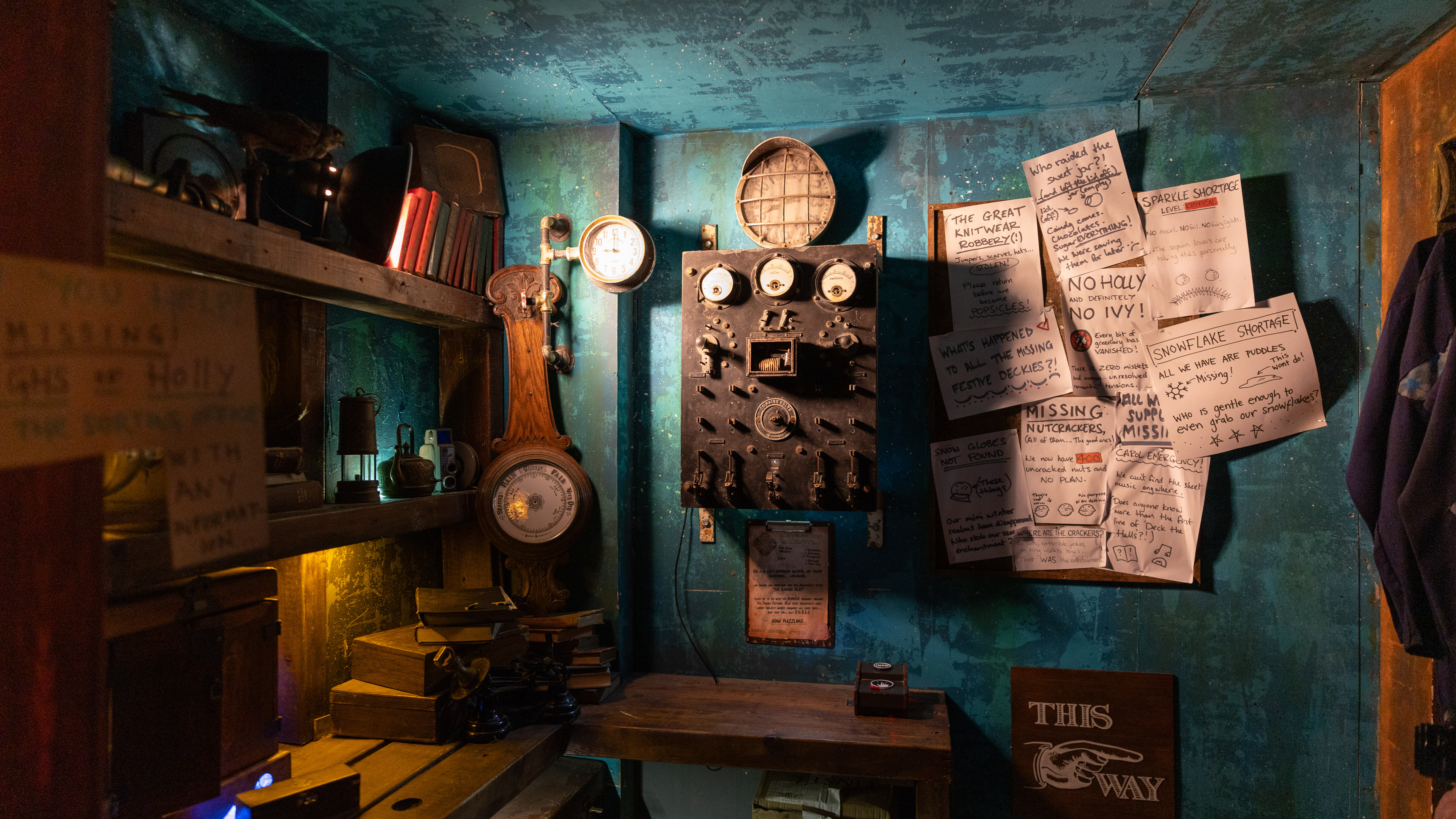 An indoor scene where various objects are laid out in a steam punk style scene, including paper notes, clocks, books, and various mechanical contraptions.