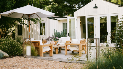 deck with garden furniture and umbrella, gravel landscaping and ornamental grasses